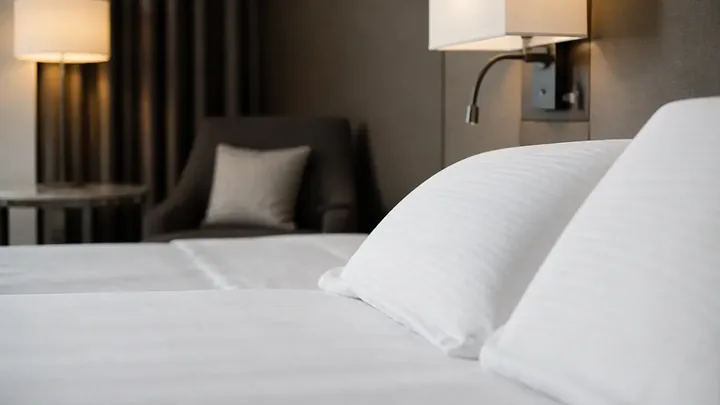 Close-up of bed pillows with an armchair blurred in the background
